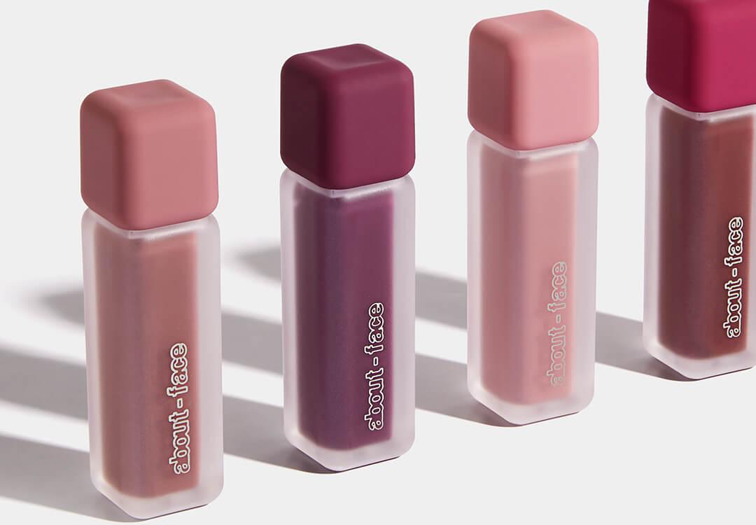 Four ABOUT-FACE Matte Paint-It Lip Colors in various shades on white background Desktop