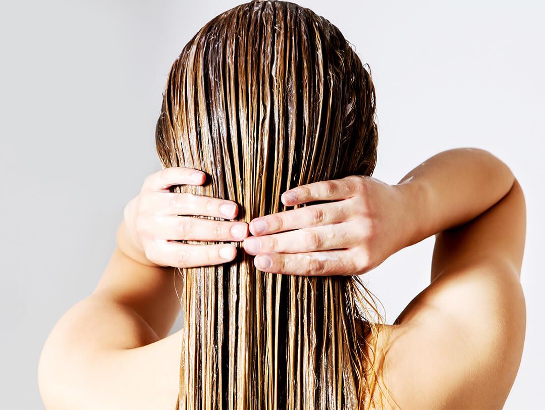 Rear view image of woman applying conditioner on hair against white background Desktop