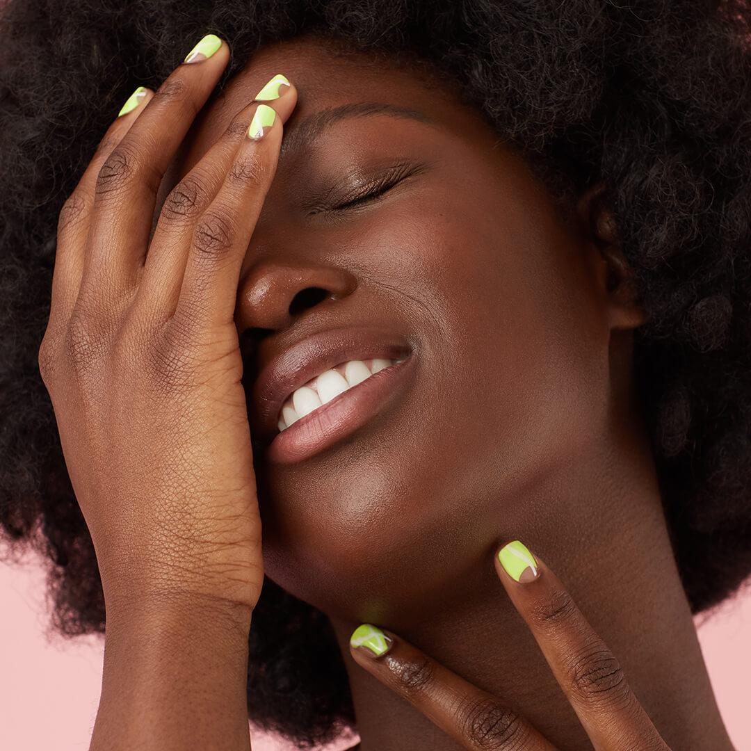 Close-up of a Black model with clear skin posing with her hands with slime green abstract nail art Mobile