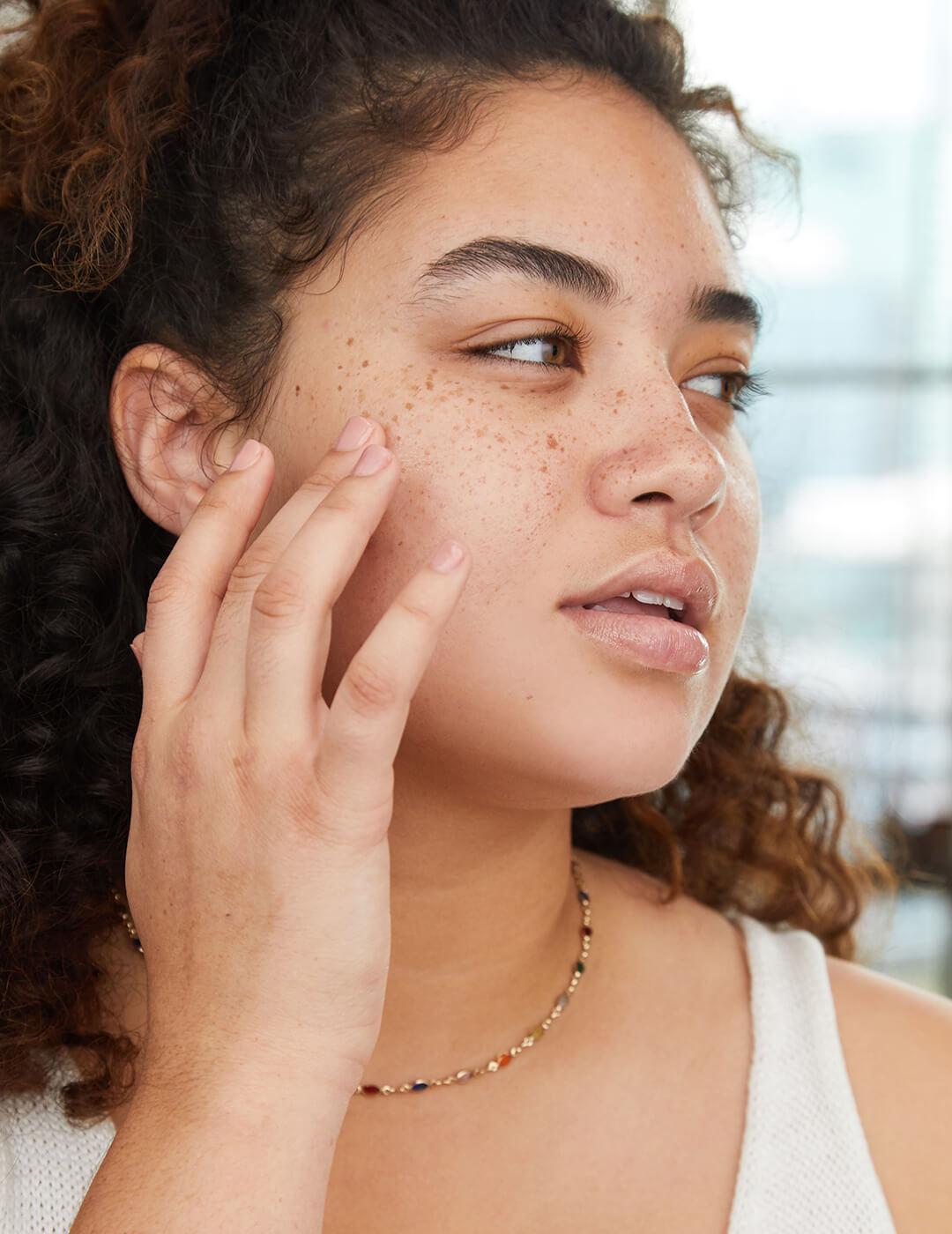 Close-up image of a model touching her cheek with a finger Mobile