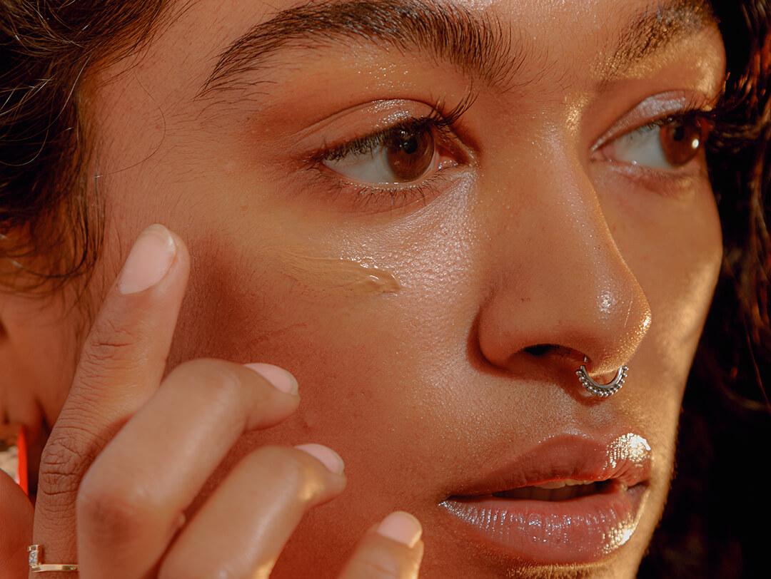 Portrait of a young woman applying liquid foundation Desktop