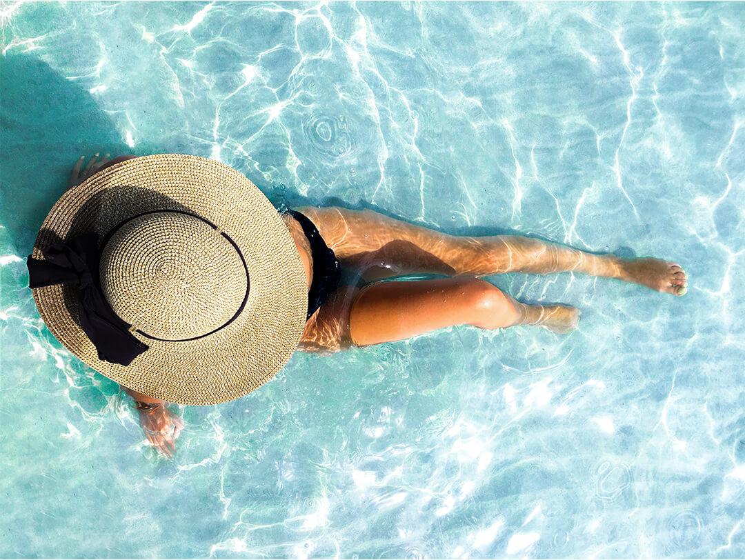 Top view image of a woman in a black bikini and straw hat chilling at the beach Desktop