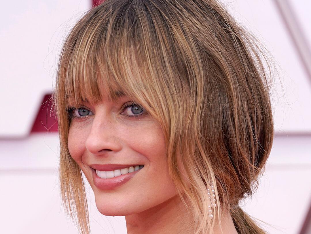 Smiling Margot Robbie rocking a no-makeup makeup look and bottleneck bangs on the red carpet Desktop