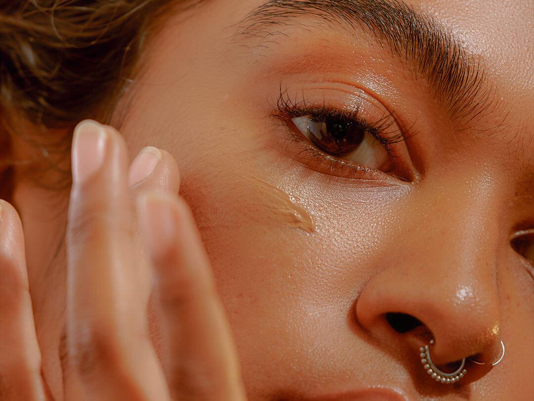 A woman applying foundation to her smooth, flawless cheek Desktop