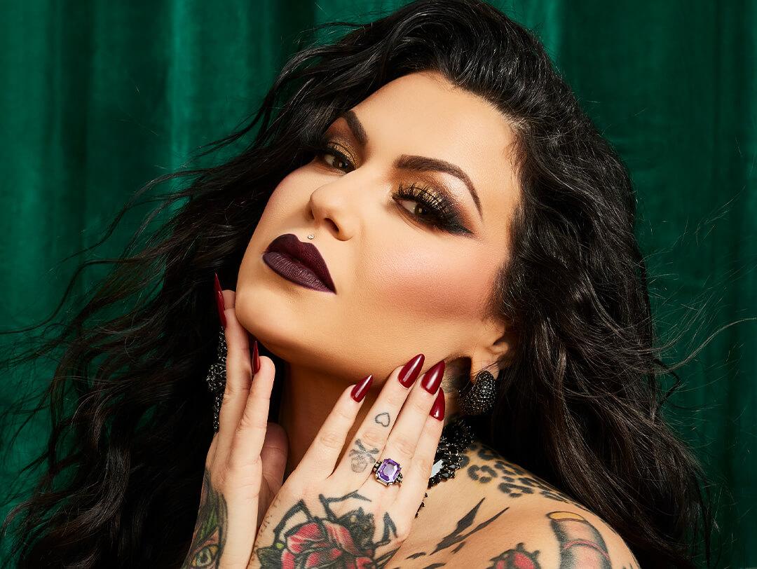 Close-up of Bailey Sarian posing in front of dark green velvet curtains Desktop