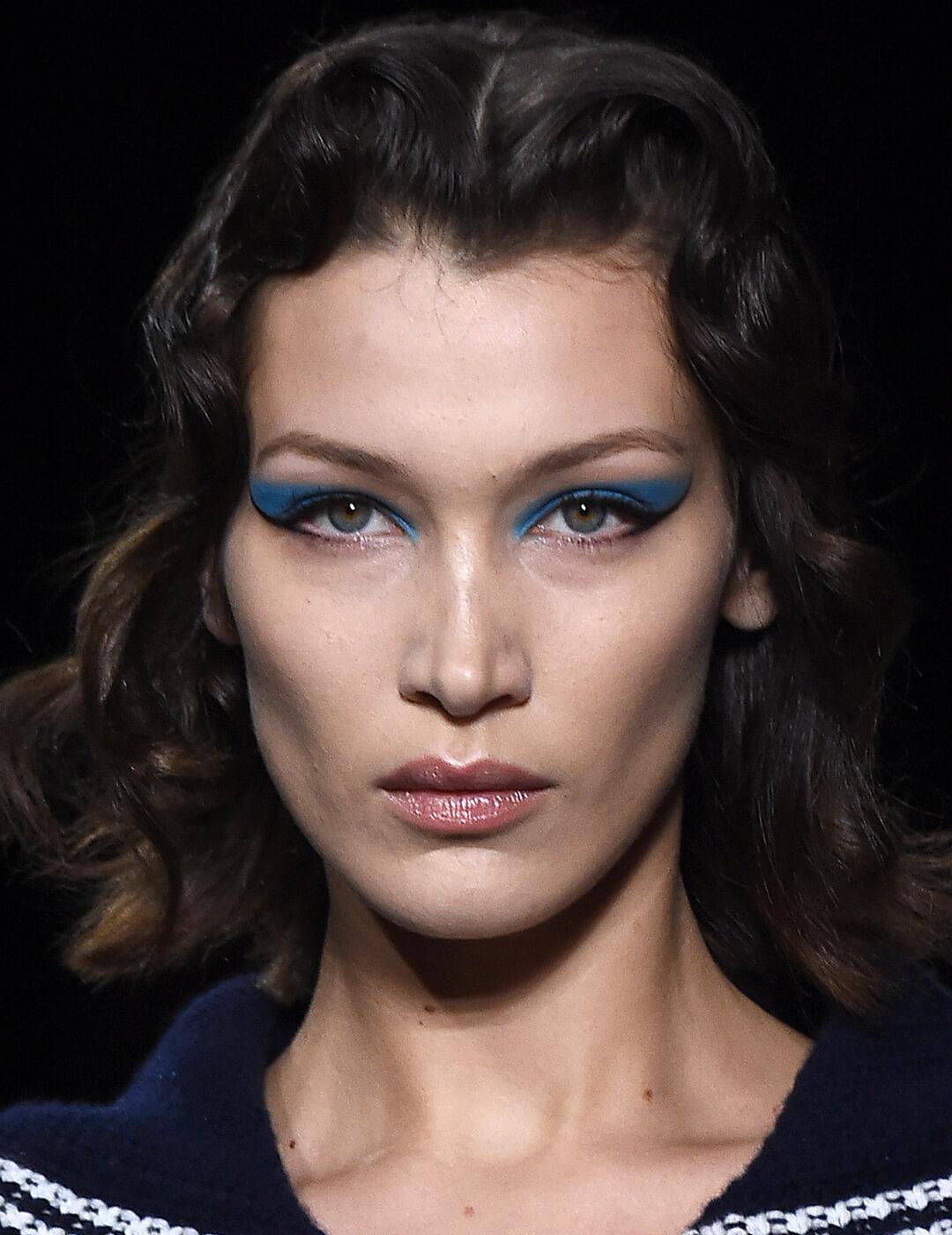 Close-up of Bella Hadid's blue eyeshadow and black winged eyeliner makeup look on the runway Mobile