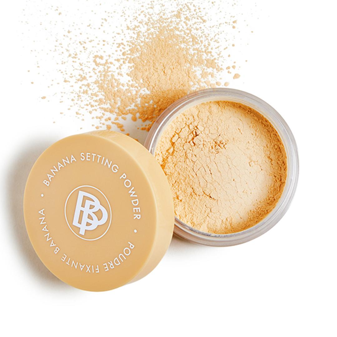 A photo of a Banana Setting Powder with some products scattered on a white background Desktop