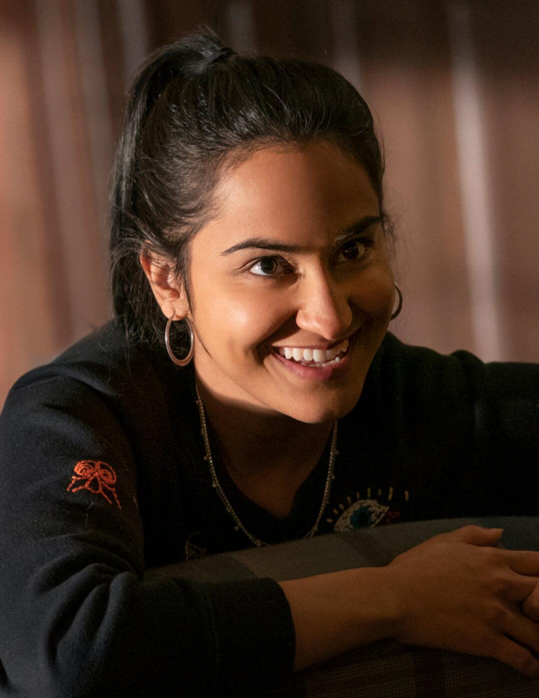 Close-up of a smiling Amrit Kaur as Bela in the HBO Max series The Sex Lives of College Girls Desktop