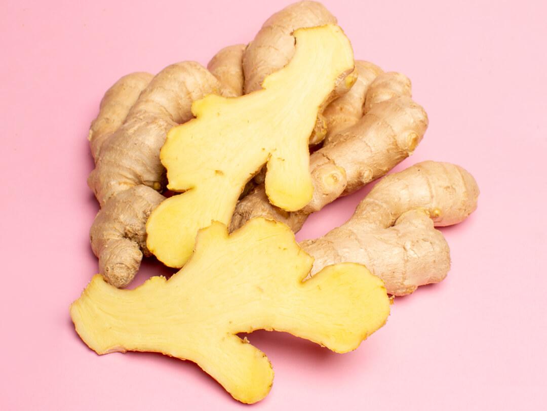 Close-up image of sliced ginger root on pink background Desktop