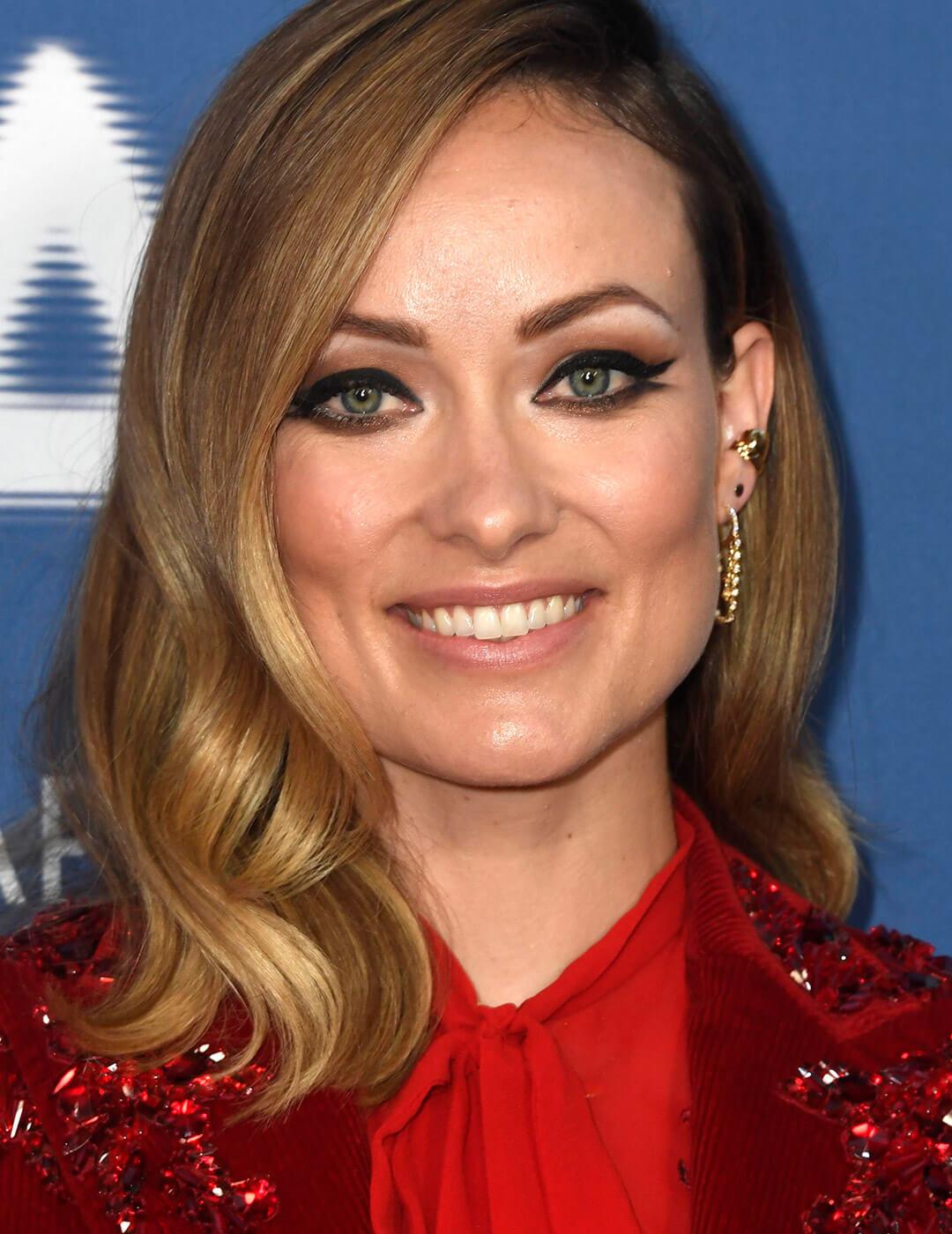 Smiling Olivia Wilde rocking a red sequined dress and smudged double wing eyeliner look Mobile