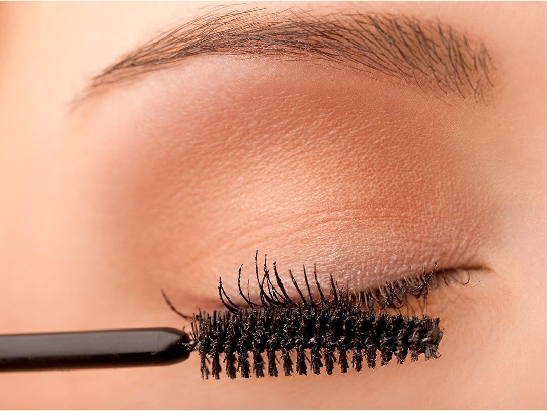 Close-up image of woman applying mascara Desktop