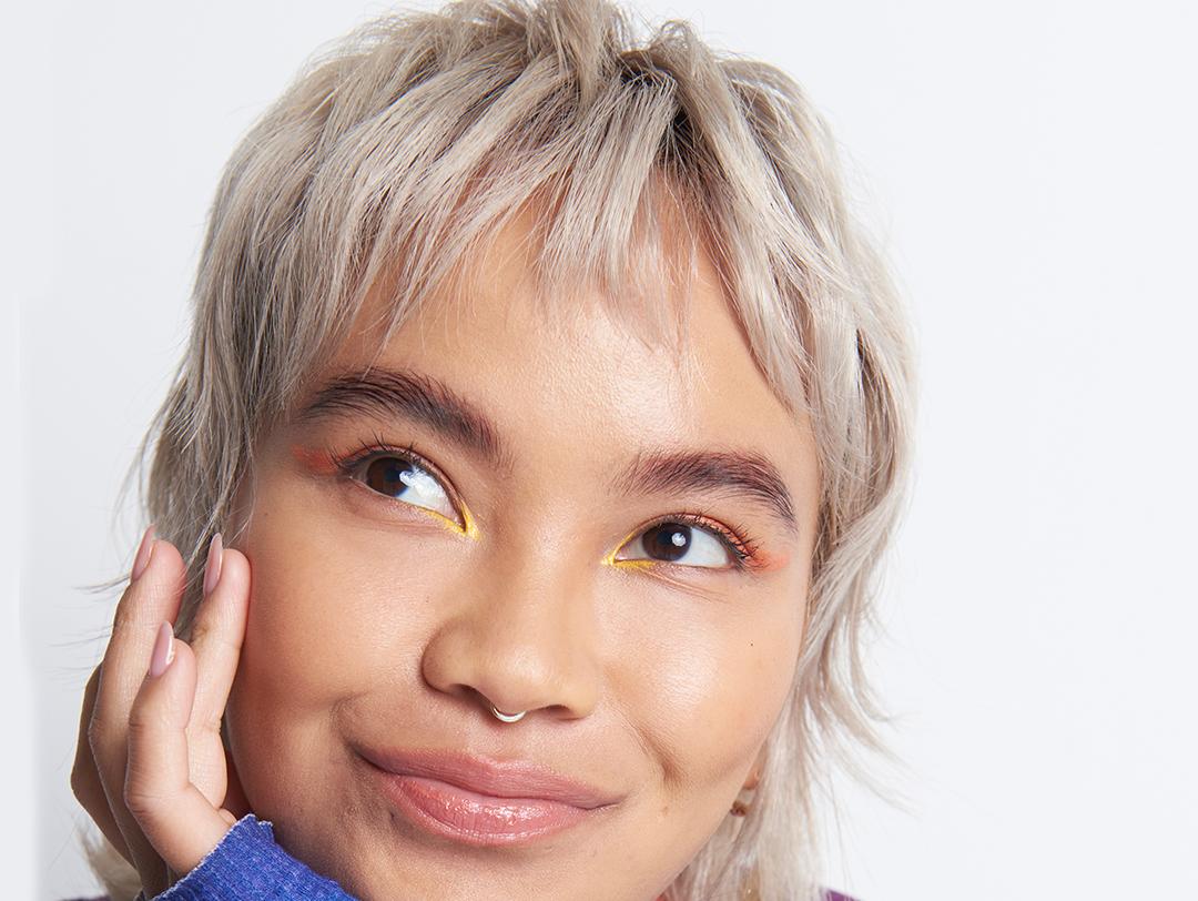 An image of a blonde woman looking sideways with her hand on her chin on a white background Desktop