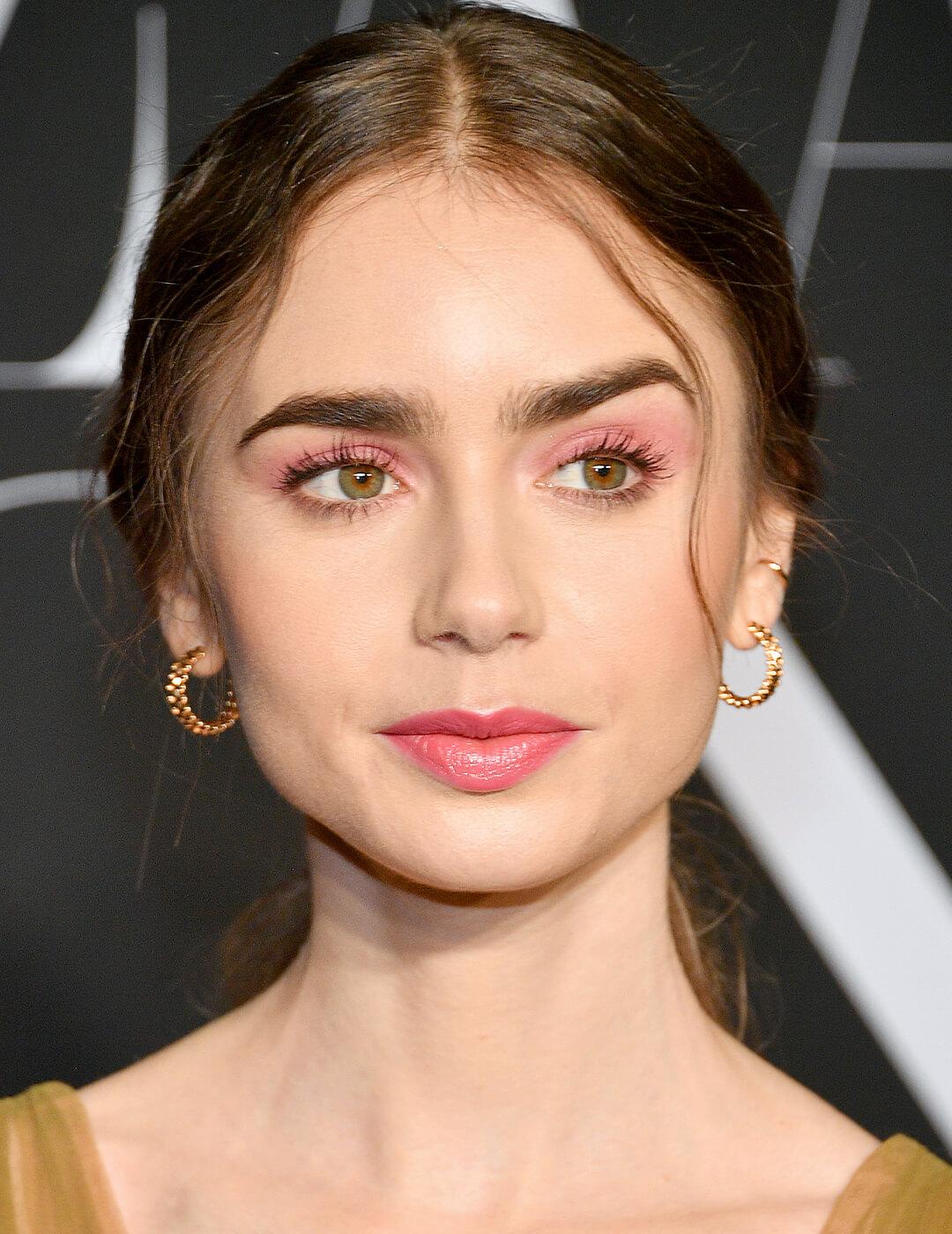 Lily Collins rocking a pink monochromatic makeup look and mustard dress on the red carpet Desktop