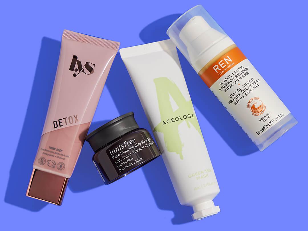 Flat lay image of face masks from various brands on blue background Desktop