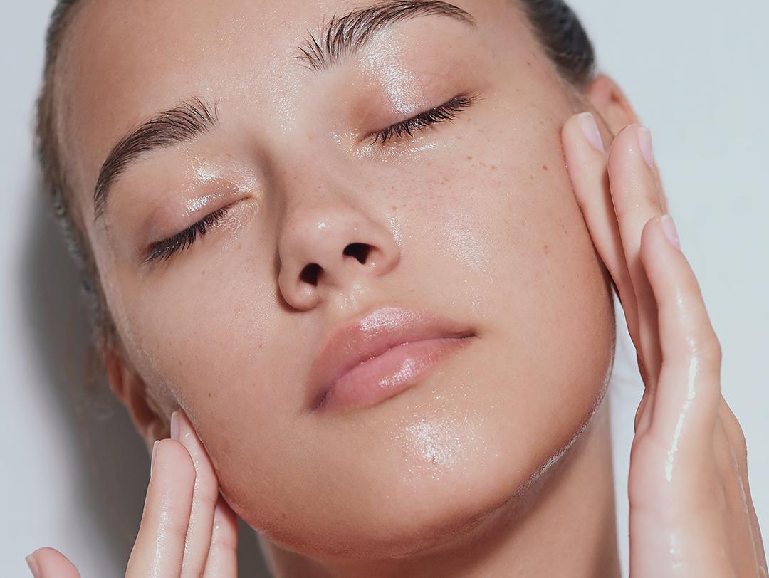 An image of a woman touching her moistened cheeks on a white background Desktop