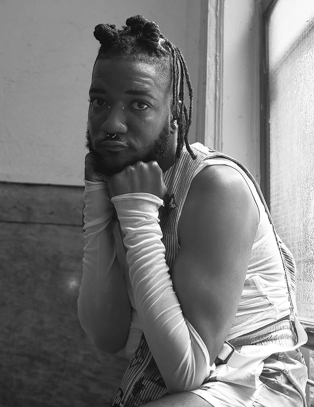 Black and white portrait of Bryce Anthony sitting and posing by the window Mobile