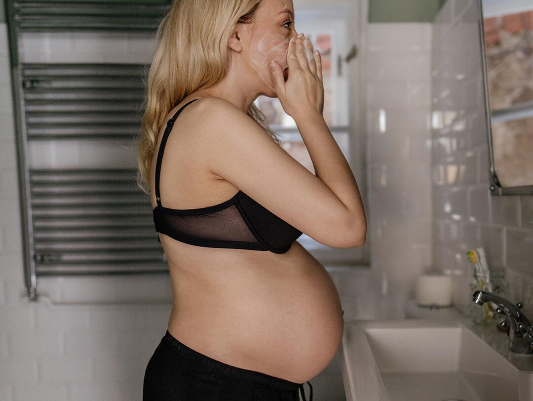 A photo of a pregnant woman in bathroom, doing her morning routine Desktop