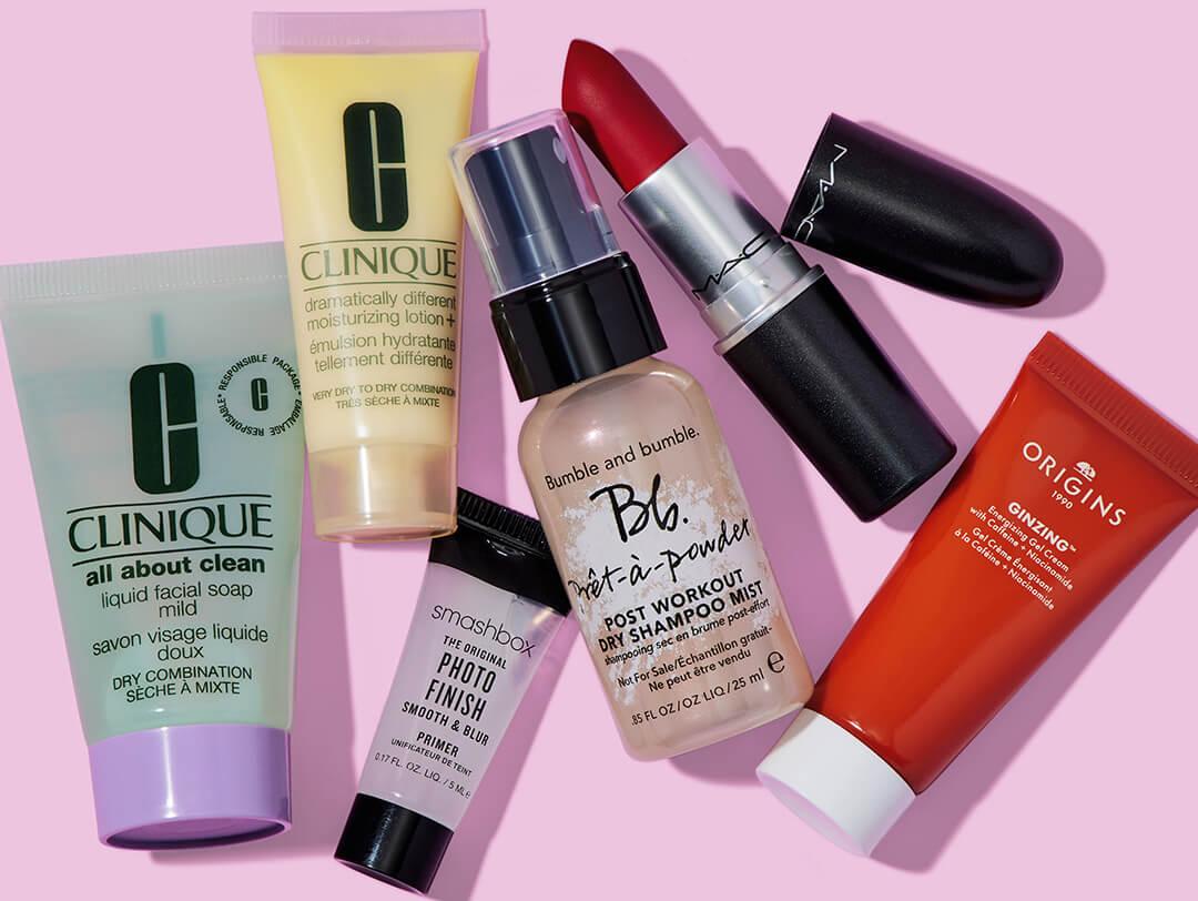 Beauty products from various brands on light pink background Desktop