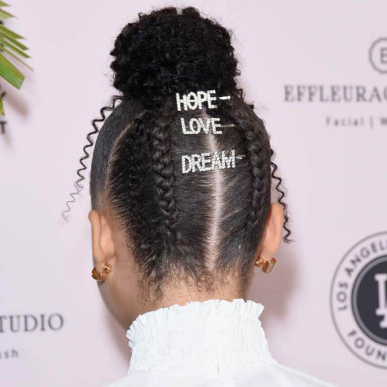 An image of Storm Reid's top bun and braids embellished with statement hair clips Desktop