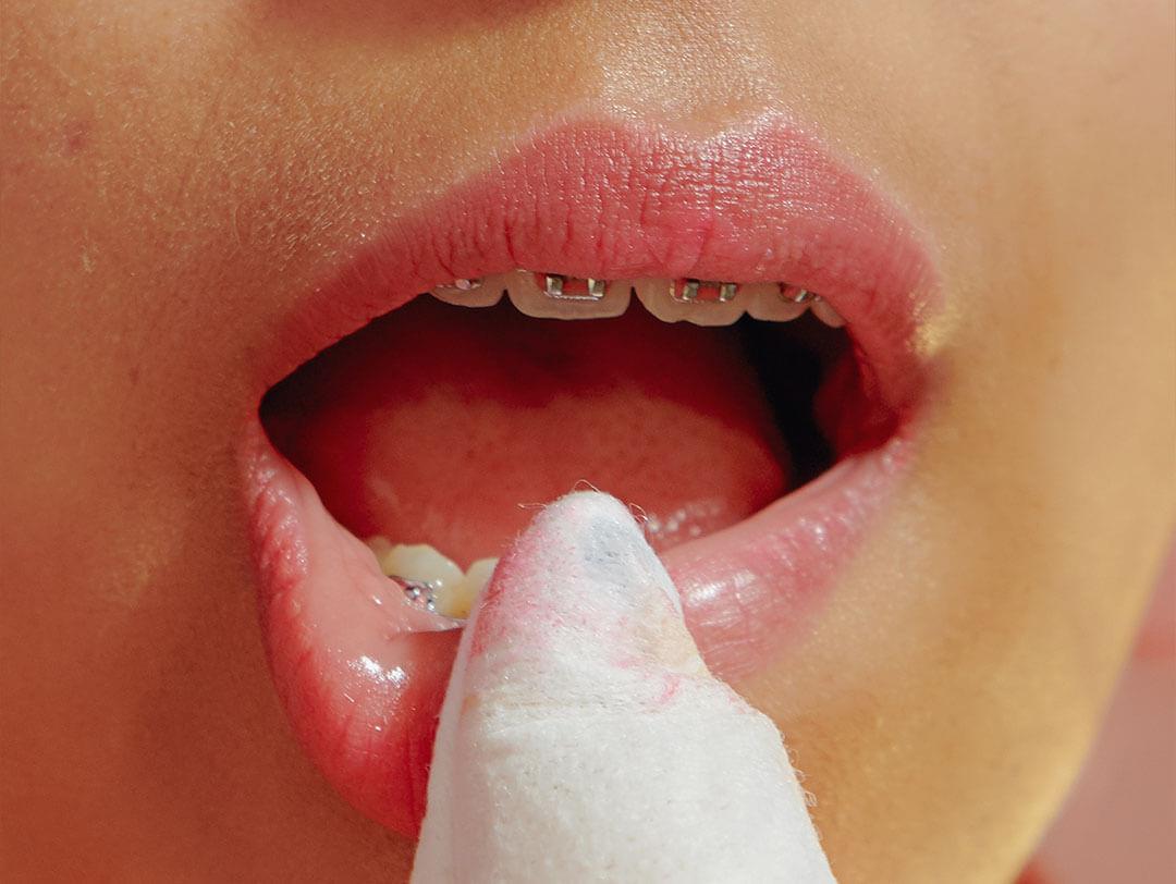 Expert young girl showcasing effective way to gently and safely remove lipstick and lip stains Desktop