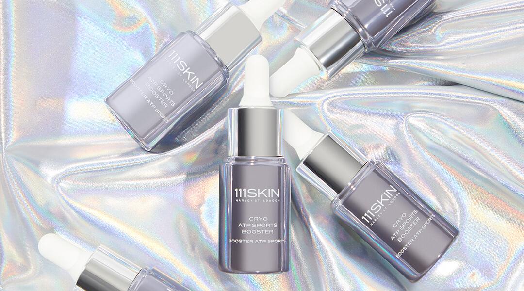 Flatlay image of five bottles of 111SKIN Cryo ATP Sports Booster on a chrome background Desktop