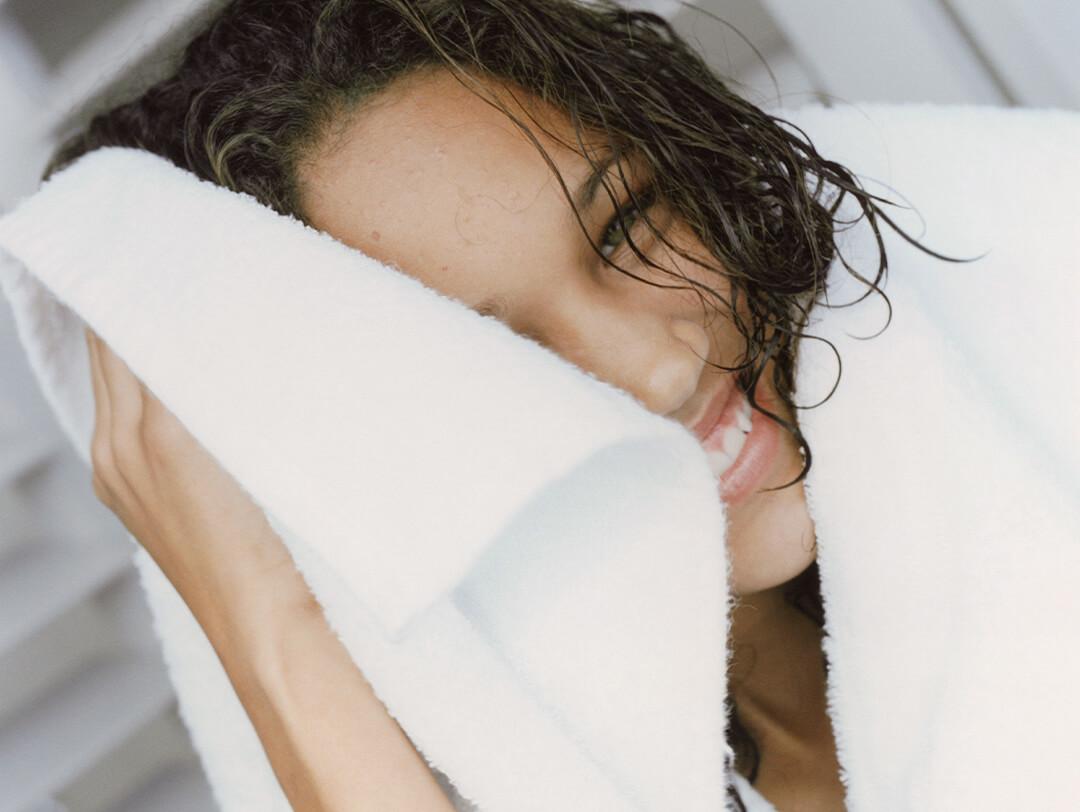 Young woman drying her wet hair with a white towel Desktop