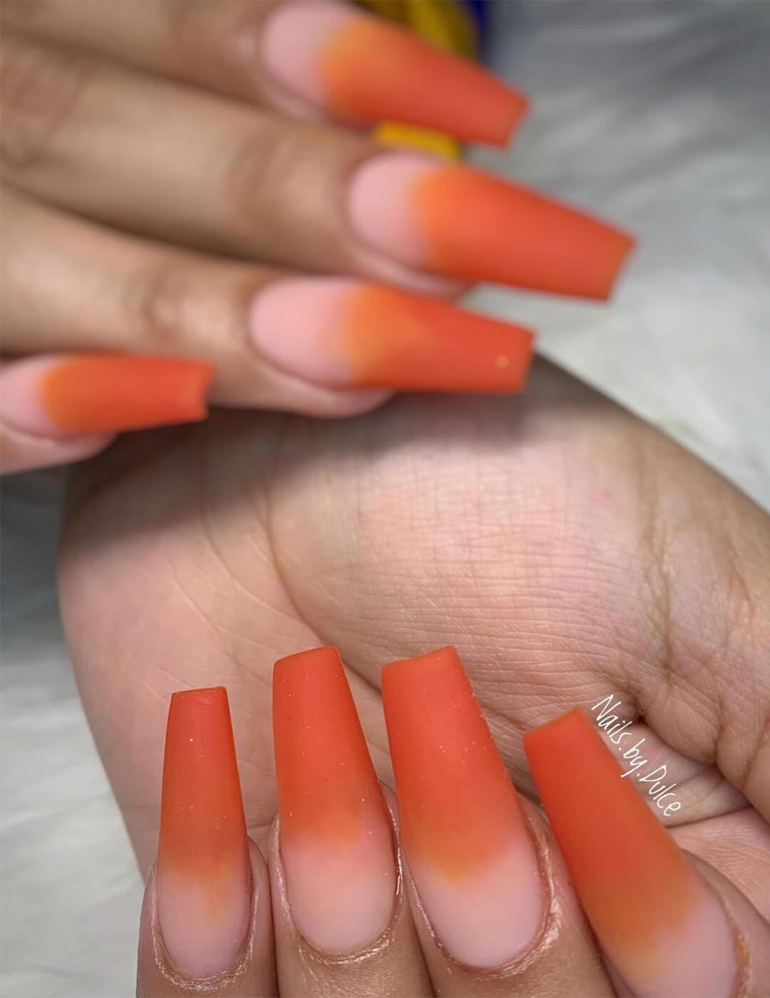 Close-up of a woman's hands with matte orange ombré nail art Mobile
