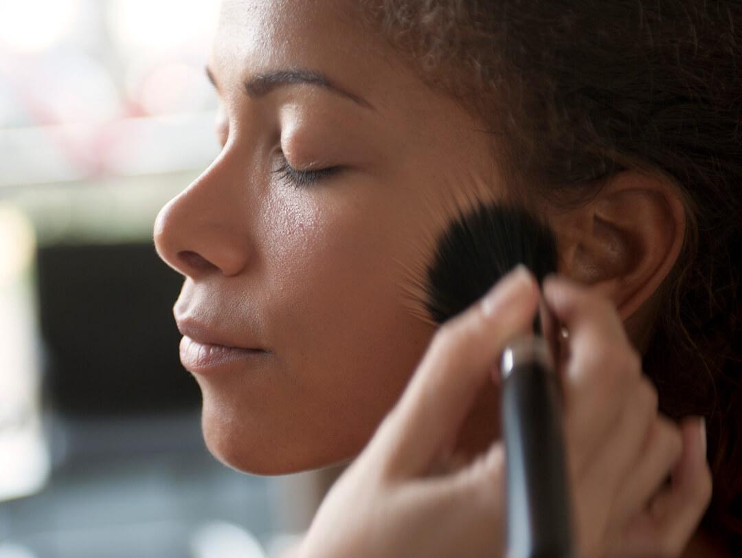 Woman of color being applied foundation on with makeup brush Desktop