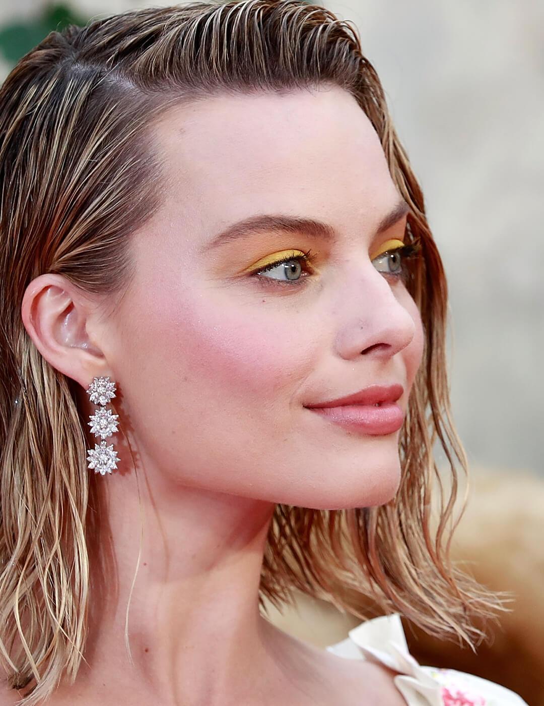 Margot Robbie rocking a wet look hairstyle and buttery yellow eye makeup look Mobile