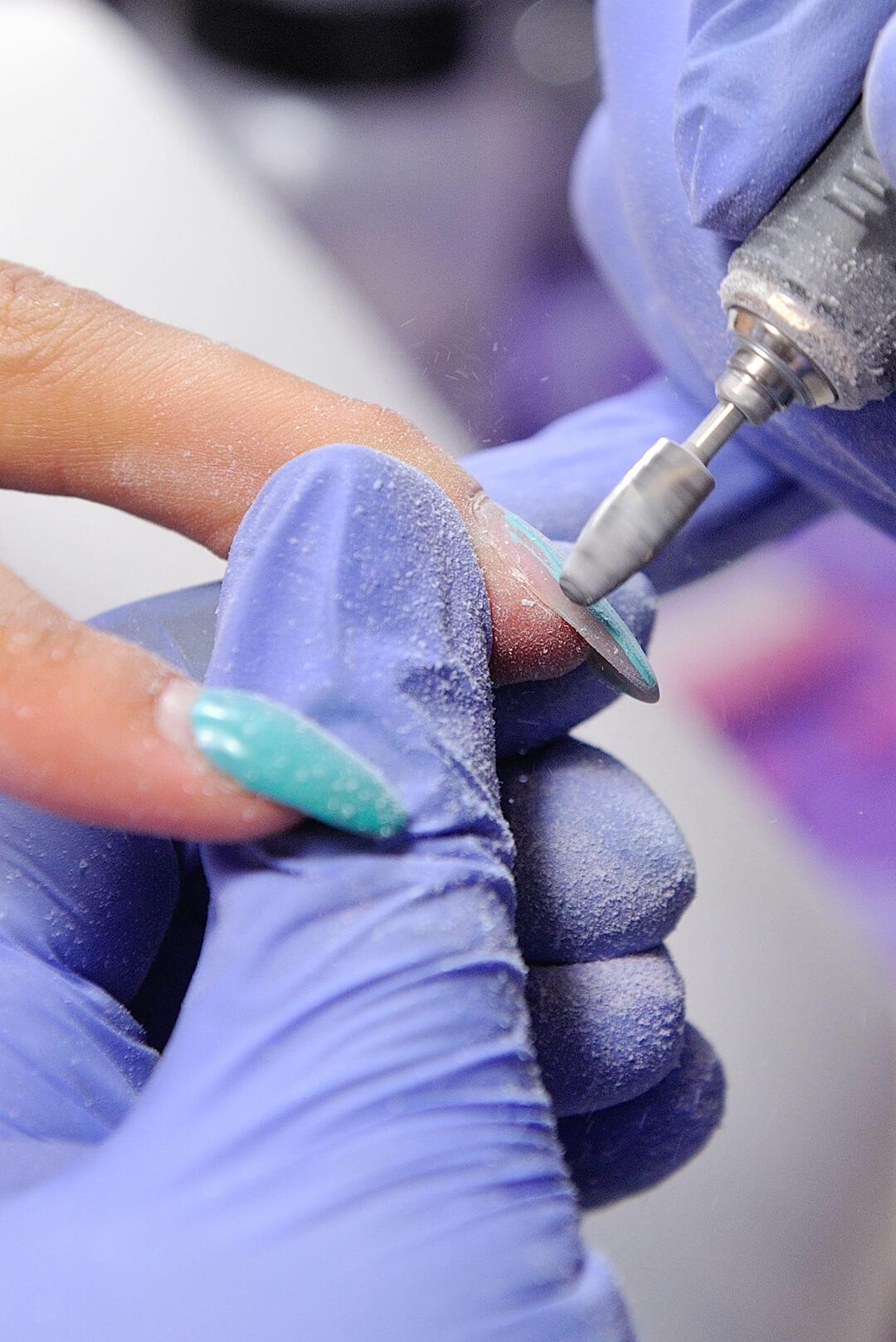 Repair old gel nails with a nail grinder in the nail salon Desktop