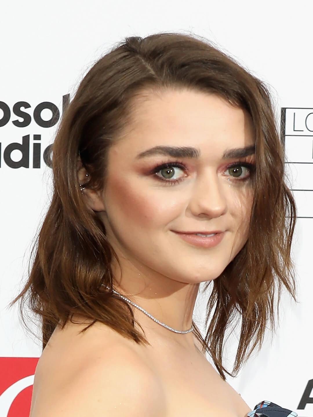 Maise Williams rocking a side part wavy hairstyle Mobile