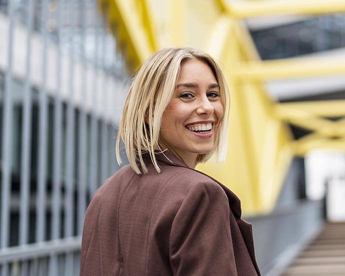 Portrait of happy young businesswoman on a bridge in the city